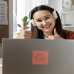 Jovem usando fones modernos, com notebook aberto, envolvido em uma sessão de aprendizado remoto