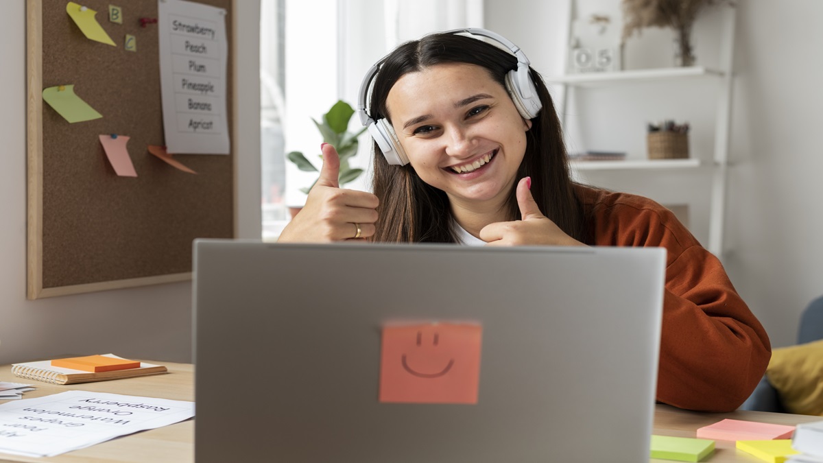 Jovem usando fones modernos, com notebook aberto, envolvido em uma sessão de aprendizado remoto